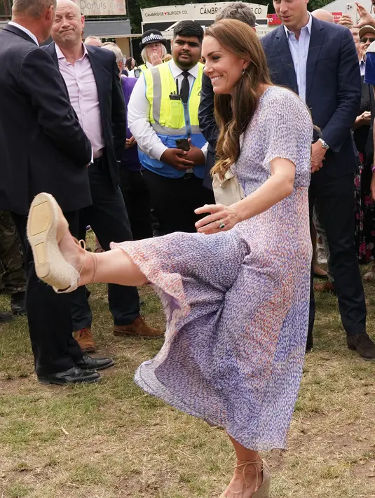 Kate Middleton saat menendang bola selama kunjungan ke Cambridgeshire County Day sebagai bagian dari perayaan Platinum Jubilee Ratu Elizabeth di Newmarket Racecourse (23/6/2022). (AFP/Pool/Paul Edwards)