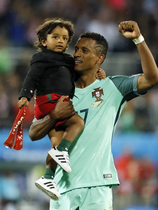 Pemain Portugal, Luis Nani merayakan kemenangan Portugal atas Prancis bersama anaknya  usai meraih trofi juara Piala Eropa 2016 di  Stade de France, Saint-Denis, Prancis, (10/7/2016). Portugal menang atas Prancis 1-0. (REUTERS/Gonzalo Fuentes)