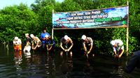 Aksi menanam pohon mangrove di Pantai Ketapang, Kota Probolinggo, Jawa Timur, memperingati Hari Laut Sedunia. (Liputan6.com/Dian Kurniawan)