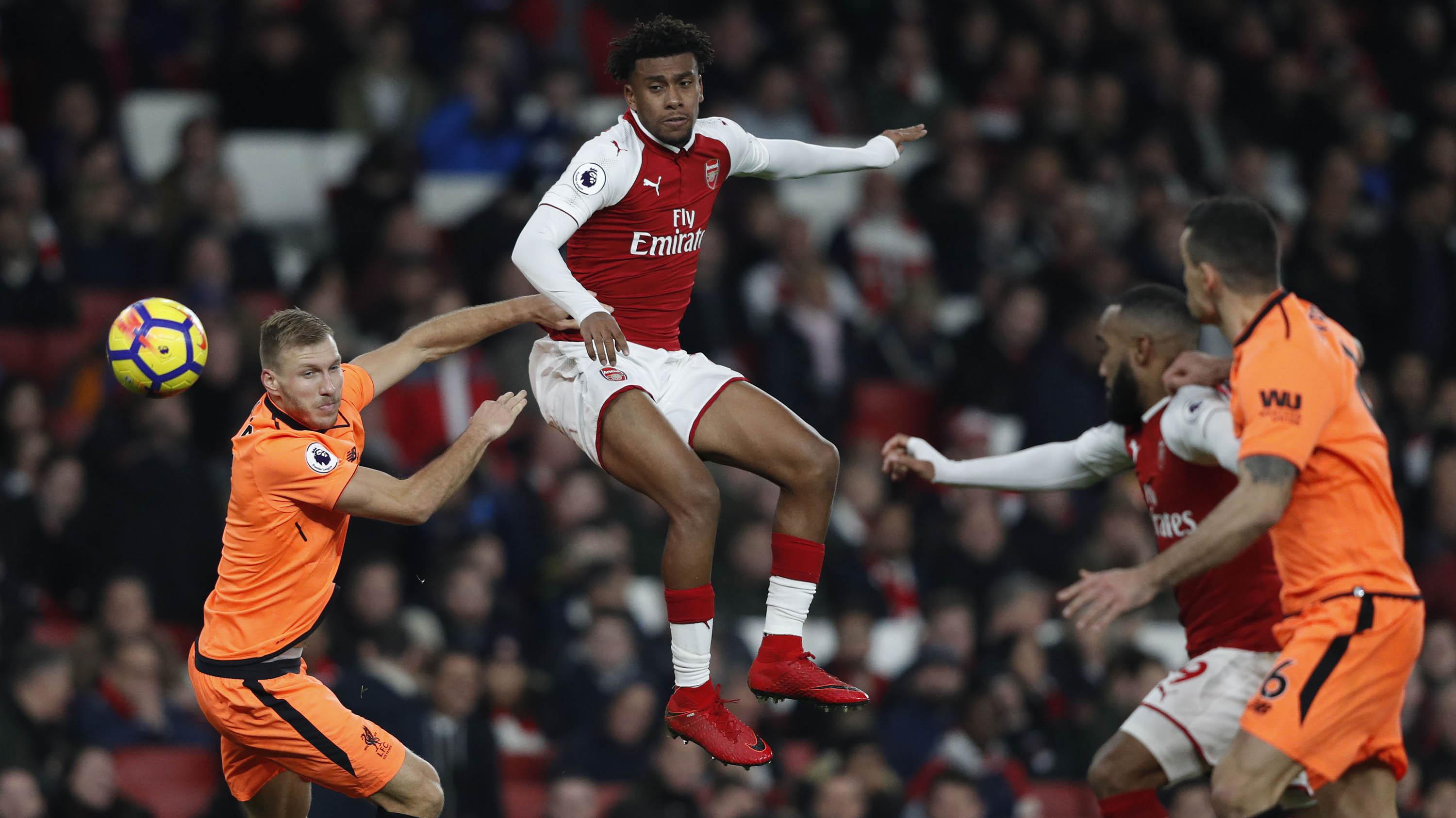 Winger Arsenal, Alex Iwobi, melepas sundulan saat melawan Liverpool pada laga Premier League di Stadion Emirates, London, Jumat (22/12/2017) (AFP/Ian Kington)