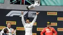 Pebalap Mercedes Lewis Hamilton (tengah) melemparkan trofi juara ke udara didampingi pebalap Mercedes Valtteri Bottas (kiri) dan pebalap Ferrari Charles Leclerc setelah menjuarai F1 GP Prancis 2019 di Sirkuit Paul Ricard, Minggu (23/6/2019). (AP Photo/Claude Paris)