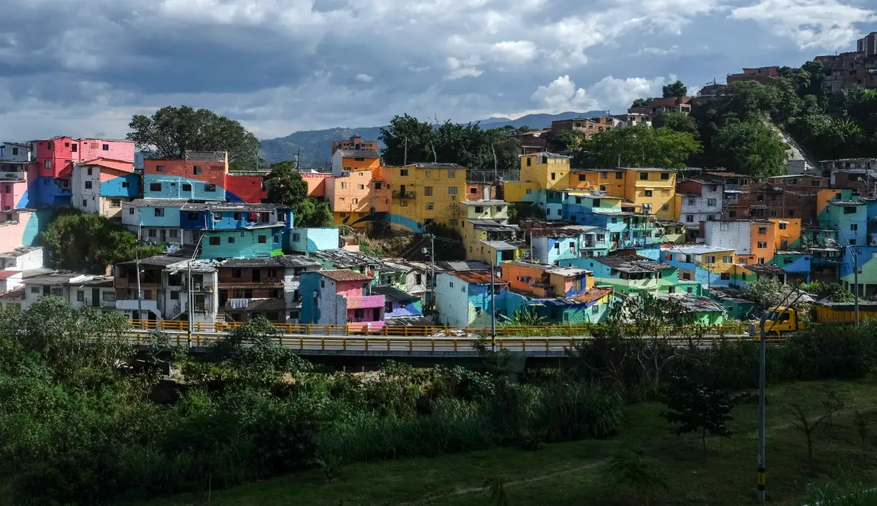 Pemandangan dari jauh memperlihatkan kawasan kumuh El Pesebre, pinggiran Medellin, Kolombia, 19 Juni 2017. Seniman Prancis, Tarik Bouanani melukis 230 rumah di kawasan itu sebagai bagian dari proyek seninya membentuk mural raksasa. (JOAQUIN SARMIENTO/AFP)