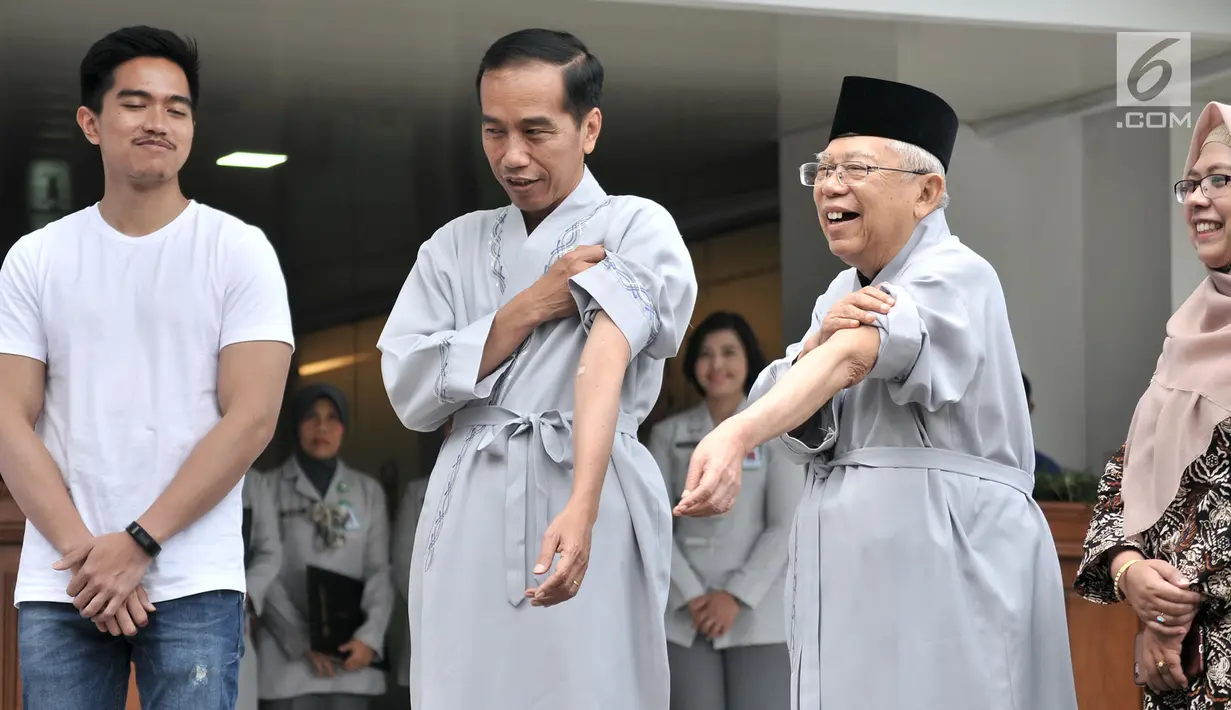 Bakal calon presiden dan wakil presiden Joko Widodo atau Jokowi (dua kiri) dan KH Ma'ruf Amin (dua kanan) menunjukkan tangan mereka sebelum tes kesehatan di RSPAD Gatot Subroto, Jakarta, Minggu (12/8). (Merdeka.com/Iqbal Nugroho)