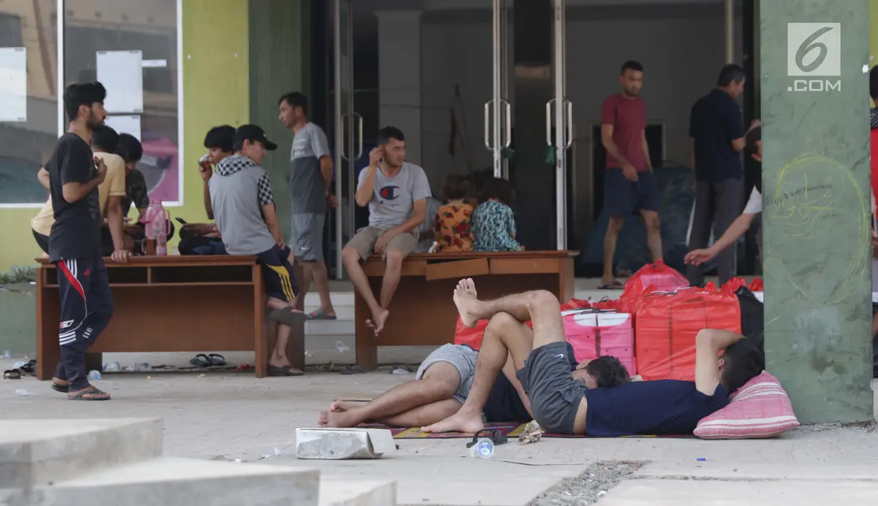 Aktivitas para pencari suaka yang masih bertahan di gedung bekas Markas Kodim, Kalideres, Jakarta, Selasa (3/9/2019). Pemprov DKI Jakarta memberikan batas waktu hingga 31 Agustus 2019,  namun masih banyak pencari suaka memilih bertahan di gedung itu. (Liputan6.com/Helmi Fithriansyah)