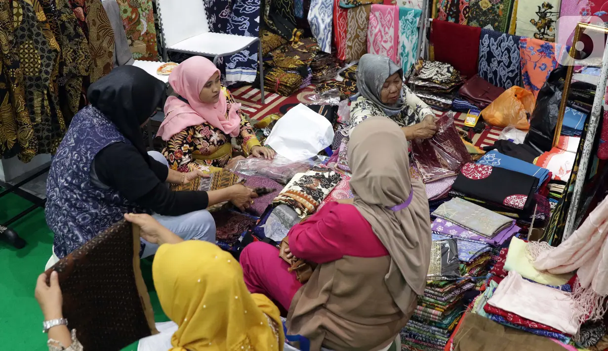 Pengunjung memilih koleksi batik yang dipamerkan pada Interior and Craft (ICRA) Exhibition 2019 yang dihelat di Hall A Jakarta Convention Center (JCC), Senayan, Jakarta, Minggu (6/10/2019). Ratusan motif batik dari berbagai daerah dipamerkan pada ajang ini. (Liputan6.com/Helmi Fithriansyah)