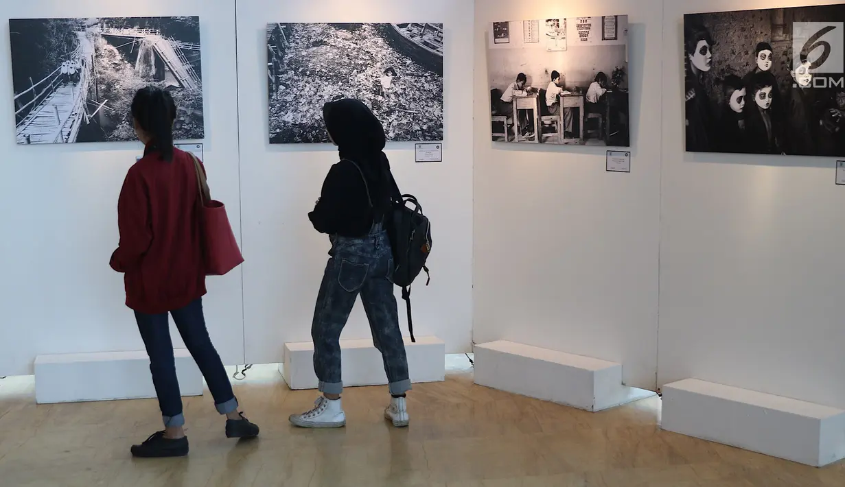 Pengunjung mengamati karya yang dipajang dalam pameran fotografi bertajuk “Semangat Anak Indonesia dalam Bingkai Hitam Putih” di Taman Ismail Marzuki (TIM), Jakarta, Selasa (20/3). (Liputan6.com/Immanuel Antonius)