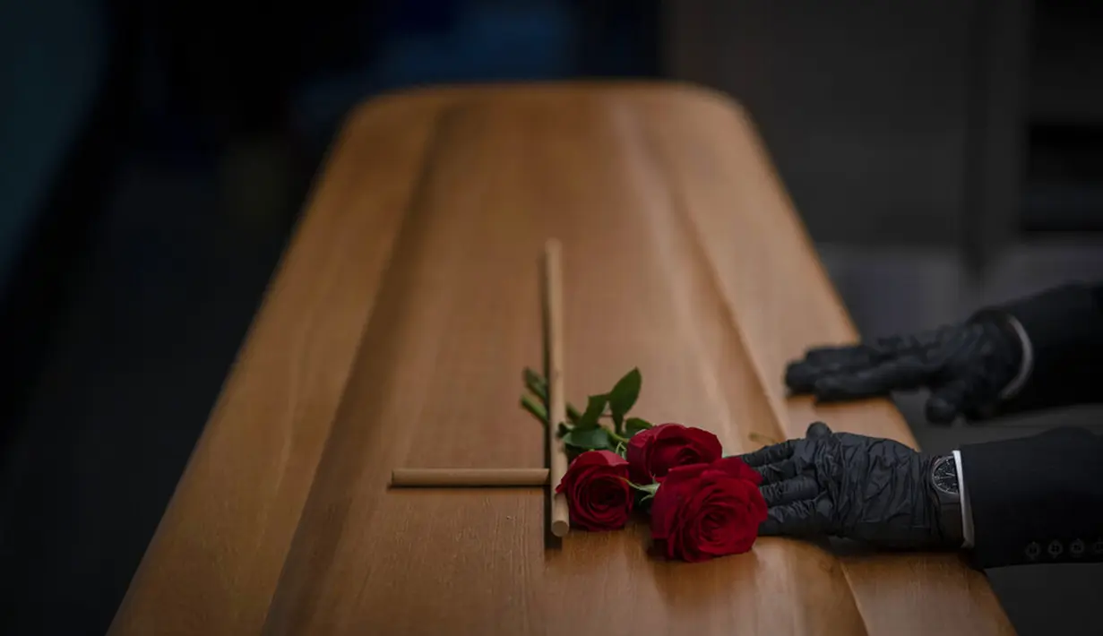 Petugas kamar jenazah menyiapkan peti jenazah korban COVID-19 sebelum dikremasi saat pemakaman di kamar jenazah Memora, Girona, Spanyol, 19 November 2020. Seperti dokter dan perawat, petugas kamar jenazah adalah bagian dari sekelompok pekerja penting di tengah pandemi. (AP Photo/Emilio Morenatti)