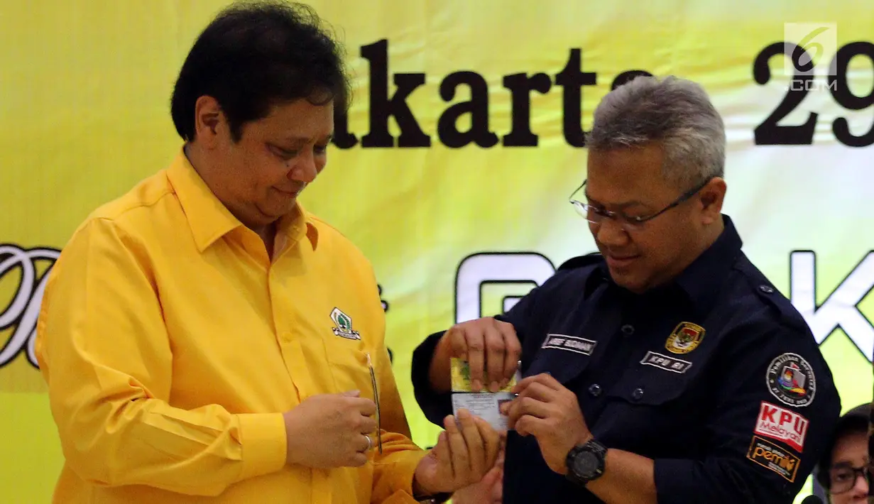 Ketua Umum Partai Golkar Airlangga Hartarto menyerahkan Kartu Anggota Partai Golkar kepada Ketua KPU Arief Budiman saat Verifikasi Faktual Partai Politik Tingkat Pusat Pasca Putusan MK di DPP Golkar, Jakarta, Senin (29/1). (Liputan6.com/JohanTallo)