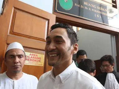 Aktor Restu Sinaga berjalan keluar ruang sidang PN Jakarta Selatan, Selasa (20/12). Majelis Hakim menunda sidang pembacaan putusan kasus narkotika Restu Sinaga lantaran salah satu Hakim Anggota berhalangan hadir. (Liputan6.com/Herman Zakharia)