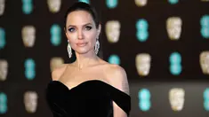 Aktris Angelina Jolie berpose saat tiba di BAFTA Awards 2018 di London, Inggris (18/2). Angelina tampil cantik dan seksi mengenakan gaun berwarna hitam dengan pundak terbuka. (Photo by Vianney Le Caer/Invision/AP)