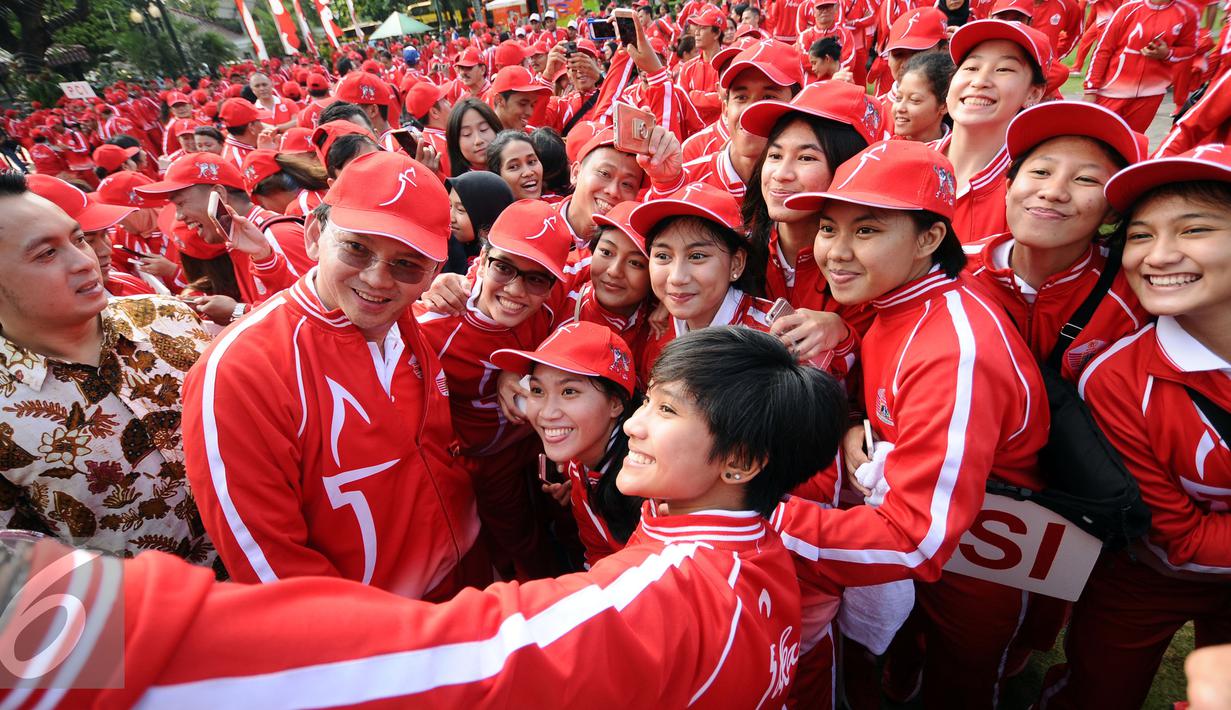 Gubernur DKI Jakarta, Basuki Tjahaja Purnama (kedua kiri) berselfie bersama tim basket putri Jakarta yang akan berlaga di PON XIX Jabar usai pelepasan di Balaikota Jakarta, Rabu (7/9). DKI Jakarta menerjunkan 1.258 atlet. (Liputan6.com/Helmi Fithriansyah)