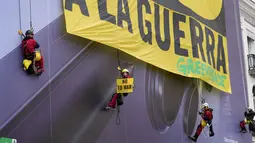 Dalam aksinya, mereka mengecam serangan militer Amerika Serikat dan Israel ke Iran dan menyerukan perdamaian. Tampak dalam foto, aktivis Greenpeace membentangkan spanduk besar bertuliskan "Tidak untuk Perang" sebagai bentuk protes terhadap serangan Amerika Serikat (AS) dan Israel terhadap Iran, di Lapangan Puerta del Sol, Madrid, Spanyol, pada Selasa 10 Maret 2026. (Paul Hanna/AFP)