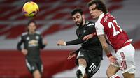 Bek Arsenal, David Luiz (kanan), berusaha menghalau bola saat mengawal ketat playmaker Manchester United, Bruno Fernandes. Arsenal dan Manchester United bermain imbang tanpa gol dalam laga pekan ke-21 Premier League, Minggu (31/1/2021) dini hari WIB. (Shaun Botterill/Pool via AP)