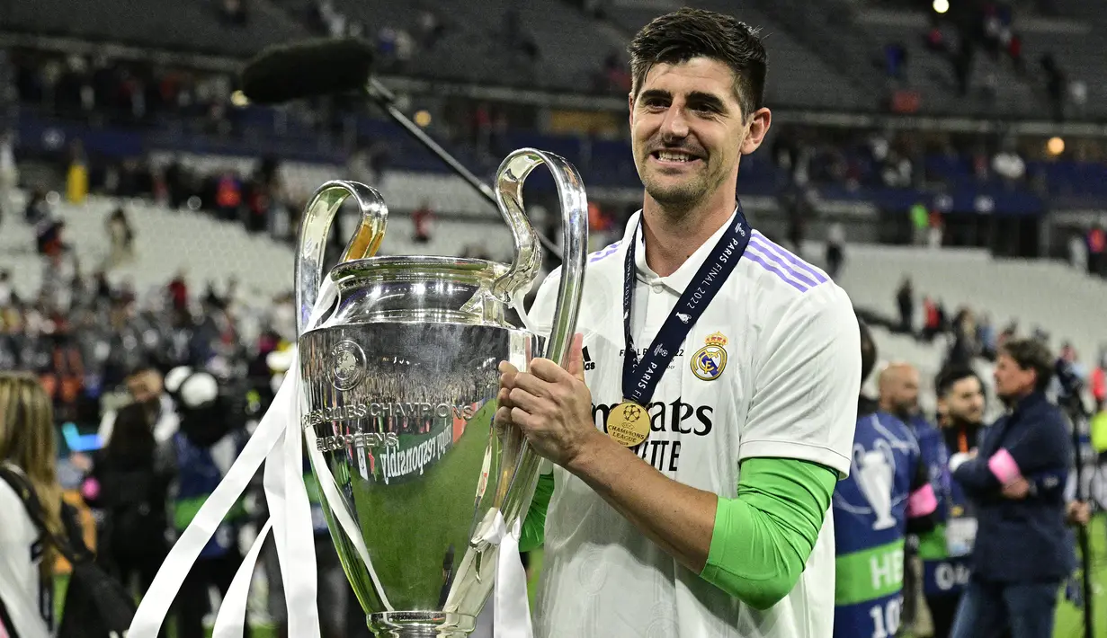 Selebrasi kiper Real Madrid, Thibaut Courtois dengan trofi Liga Champions 2021/2022 dalam perayaan gelar juara setelah mengalahkan Liverpool pada laga final di Stade de France, Saint-Denis, Paris (28/5/2022). Serupa dengan Eden Hazard, Thibaut Courtois juga mampu meraih trofi Liga Champions bersama Real Madrid pada musim 2021/2022. Ia selalu tampil penuh dalam seluruh 13 laga Los Blancos di Liga Champions musim 2021/2022 dengan mencetak 5 kali nirbobol. (AFP/Javier Soriano)