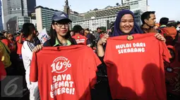 Warga ikut menggelar kampanye hemat energi bertema "Aksi Bersama Menteri ESDM Gerakan Potong 10%" pada kegiatan Car Free Day (CFD) di Bundaran HI, Jakarta, Minggu (15/5). Kampanye dilakukan dengan jalan santai di kawasan CFD. (Liputan6.com/Faizal Fanani)
