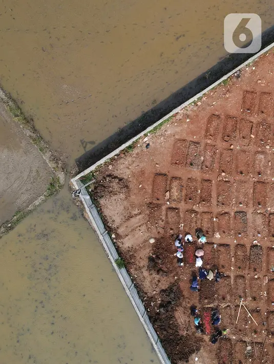Foto udara memperlihatkan kendaraan alat berat menyelesaikan penggarapan lahan untuk lokasi pemakaman khusus Covid-19 di Rorotan, Jakarta Utara, Kamis (3/6/2021). Sejak dibuka pada akhir Maret lalu, TPU ini diutamakan melayani pemakaman bagi jenazah Covid-19 ber-KTP DKI. (merdeka.com/Imam Buhori)