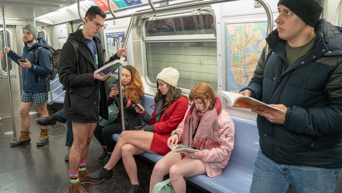 Penumpang berada di dalam kereta F selama No Pants Subway Ride ke-18 di New York City (13/1). No Pants Subway Ride ajang tahunan yang sudah menyebar ke berbagai kota besar di dunia. (AFP Photo/David 'Dee' Delgado)