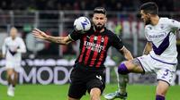 Penyerang AC Milan Olivier Giroud berebut bola dengan bek Italia Fiorentina Cristiano Biraghi pada duel pekan ke-15 Serie A 2022/2023 di San Siro, Senin (14/11/2022). AC Milan terpaut delapan angka di belakang Napoli yang menjadi pemuncak. (Filippo MONTEFORTE / AFP)