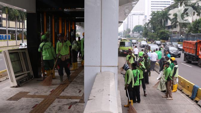 Sejumlah petugas membersihkan sisa kerusakan Halte Bus TransJakarta Tosari, Jakarta, Jumat (9/10/2020). Sejumlah fasilitas umum rusak dalam kericuhan unjuk rasa menolak pengesahan UU Cipta Kerja yang terjadi Kamis (8/10).  (Liputan6.com/Angga Yuniar)