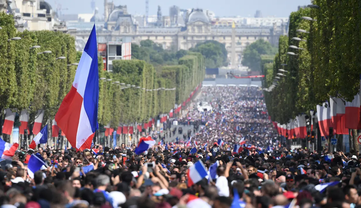 Ratusan ribu masyarakat memadati jalan Champs Elysees untuk menyambut kepulangan timnas Prancis usai menjuarai Piala Dunia 2018 di Paris, Senin (16/7). Skuad Les Bleus meraih trofi Piala Dunia usai mengalahkan Kroasia  4-2. (Eric Feferberg/Pool via AP)