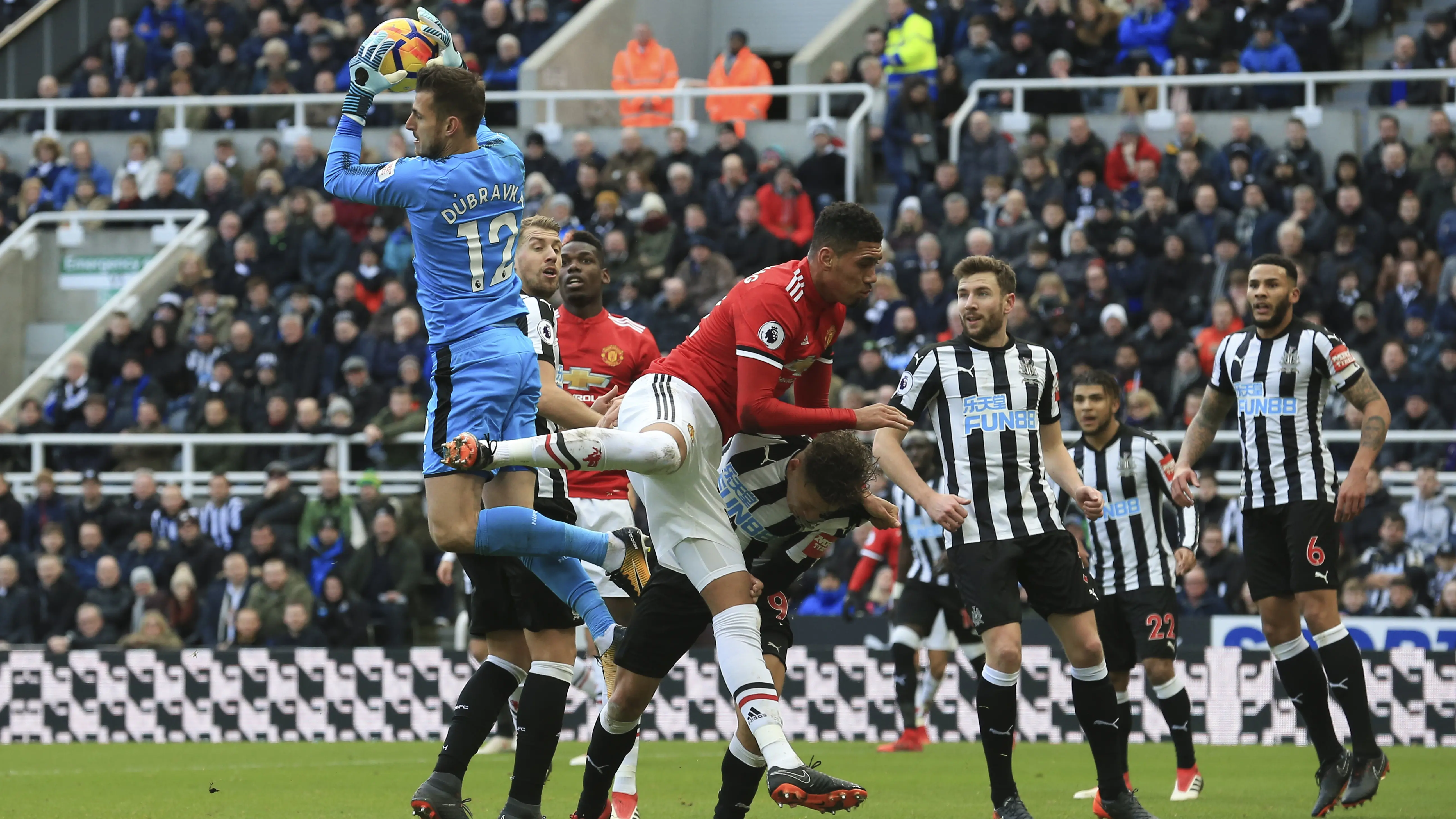 Martin Dubravka (kiri) mengamankan bola dari sundulan pemain Manchester United, Chris Smalling (tengah)  (AFP/Lindsey Parnaby)