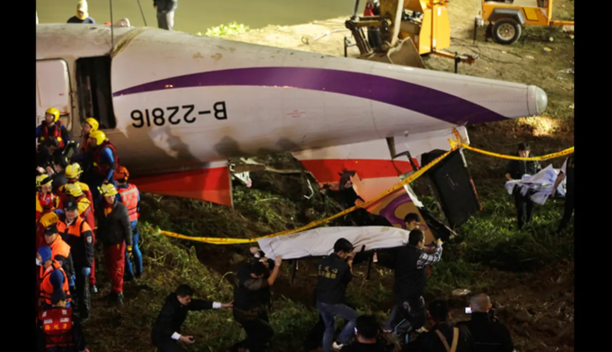 Petugas membawa satu korban kecelakaann pesawat TransAsia Airways turboprop ATR 72-600 disungai Taipe, Taiwan, Rabu (4/2/2015). Pesawat yang mengangkut 58 penumpang dan awak pesawat itu terhempas ke sungai saat hendak lepas landas. (REUTERS/Pichi Chuang)
