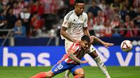 Penyerang Atletico Madrid asal Argentina, Angel Correa, berebut bola dengan bek Real Madrid asal Brasil #03, Eder Militao, sebelum mencetak gol pertama timnya selama pertandingan liga Spanyol antara Club Atletico de Madrid dan Real Madrid CF di stadion Metropolitano di Madrid pada tanggal 29 September 2024. (JAVIER SORIANO/AFP)