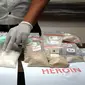 Salah satu petugas merapikan barang bukti narkotika jenis sabu saat jumpa pers di Dit Resnarkoba Polda Metro Jaya, Kamis (13/11/2014). Sebanyak 19,3 kg shabu dan 1,03 heroin disita Dit Resnarkoba Polda Metro Jaya. (Liputan6.com/Helmi Fithriansyah)