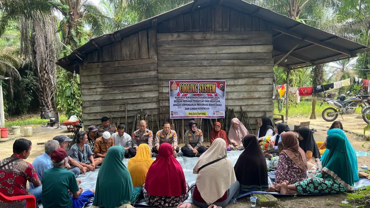Kapolsek Tapung bersama warga Desa Batu Gajah, Kabupaten Kampar, dalam sosialisasi Pilkada damai.