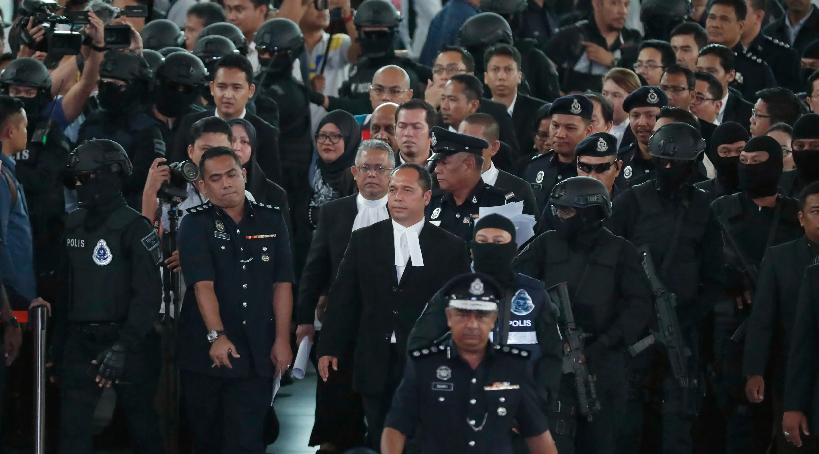 Hakim Datuk Azmi Ariffin  bersama jaksa dan pengacara tiba di Bandara Internasional Kuala Lumpur, Selasa (24/10). Hari ini, Siti Aisyah dan Doan Thi Huong melakukan reka ulang kejadian di tempat keduanya dituding meracuni Kim Jong-nam. (AP/Sadiq Asyraf)