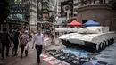 Pejalan kaki di pusat kota Hong Kong berjalan melewati sebuah replika tank yang ditampilkan untuk mengenang peristiwa yang terjadi pada 4 Juni 1989 silam di Lapangan Tiananmen, Tiongkok, (3/6/2014). (AFP PHOTO/Philippe Lopez) 