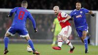 Bek Arsenal, Shkodran Mustafi (tengah) mengumpan bola dari kawalan dua pemain Olympiakos,  Guilherme dan Youssef El-Arabi  pada leg kedua 32 besar Liga Europa di stadion Emirates, London (27/2/2020).  Olympiakos menang 2-1 dan lolos dengan unggul agregat gol tandang 2-2. (AP Photo/Frank Augstein)