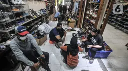 Calon pembeli saat menjajal seatu impor bekas di toko Second BJR, Kali Baru Timur, Cilincing, Jakarta Utara, Rabu (1/6/2022). Harga sepatu impor bekas mulai dijual oleh Bajuri kisaran Rp250 ribu hingga Rp7 juta per pasang. (merdeka.com/Iqbal S. Nugroho)