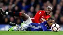 Pemain Manchester United, Paul Pogba dan pemain Chelsea, Willian, terjatuh saat berebut bola dalam perempat final Piala FA di Stadion Stamford Bridge, Senin (13/3). Chelsea lolos ke semifinal Piala FA setelah menang 1-0 atas MU. (AP Photo/Frank Augstein)