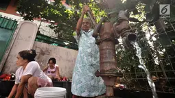 Warga menggunakan pompa air manual saat mencuci pakaian di pinggir jalan kawasan Kramat Pulo, Senen, Jakarta, Kamis (27/12). Para ibu ini mengaku harus bayar jika ingin buang air di WC umum yang berada di pemukiman. (Merdeka.com/Iqbal S. Nugroho)