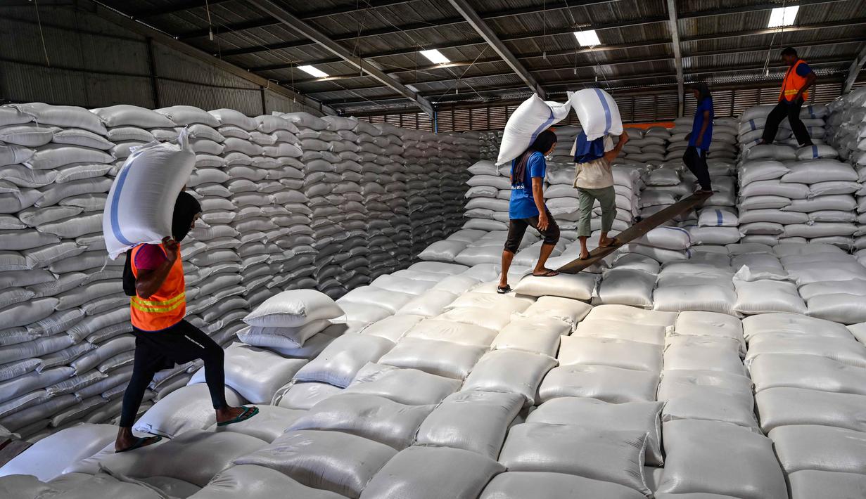 Penggunaan CBP yang dikelola Perum Bulog di tiga provinsi tersebut sedang diintensifkan untuk pelaksanaan program bantuan pangan reguler dan nonreguler. Tampak dalam foto, para pekerja menangani karung-karung beras†di gudang Badan Urusan Logistik (Bulog) di Lambaro, Provinsi Aceh pada 29 Desember 2025. (CHAIDEER MAHYUDDIN/AFP)