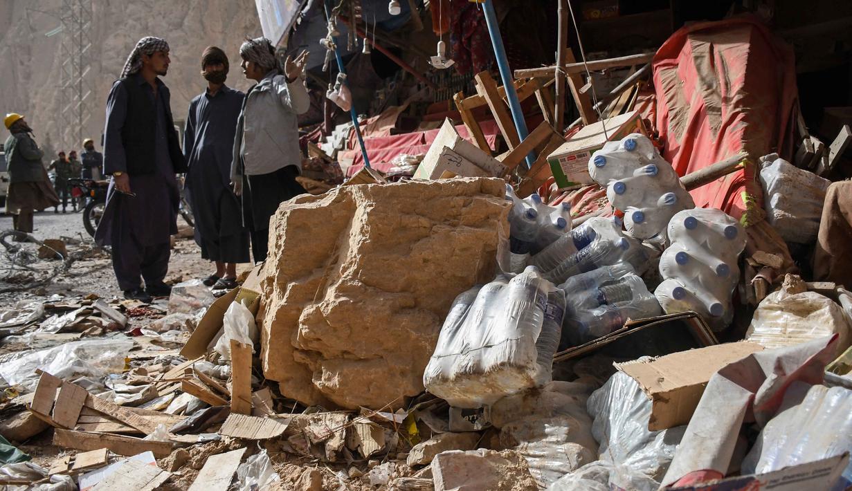 Para pemilik toko di Afghanistan mencari sisa-sisa toko mereka yang rusak di sepanjang jalan raya, menyusul gempa bumi di Tang-e Tashkurgan, distrik Khulm, provinsi Samangan, pada Senin 3 November 2025. Sebelumnya, gempa bumi terjadi di dekat Kota Mazar-e-Sharif—salah satu kota terbesar di Afghanistan yang berpenduduk sekitar 500.000 jiwa—pada Senin (3/11/2025) dini hari atau sekitar pukul 01.00 waktu setempat. (Atif Aryan/AFP)