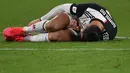 Pemain Juventus Cristiano Ronaldo terbaring di lapangan setelah ditackle pemain AS Roma Chris Smalling pada pertandingan Coppa Italia di Turin, Italia, Rabu (22/1/2020). Juventus menggilas AS Roma 3-1 dan berhasil lolos ke semifinal. (Marco Bertorello/AFP)