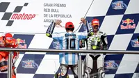 Saat menaiki podium juara, Valentino Rossi memakai jersey timnas Argentina dengan nama Diego Maradona yang merupakan legenda tim Tango. (AP Photo/Natacha Pisarenko)
