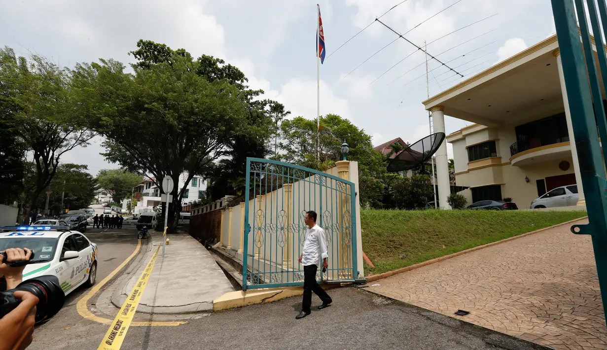 Seorang staf berjalan keluar memeriksa saat polisi Malaysia ditempatkan di depan Kedutaan Besar (Kedubes) Korea Utara di Kuala Lumpur, Selasa (7/3). Pemerintah Malaysia melarang staf Kedubes Korut keluar dari Negeri Jiran. (AP Photo/Vincent Thian)