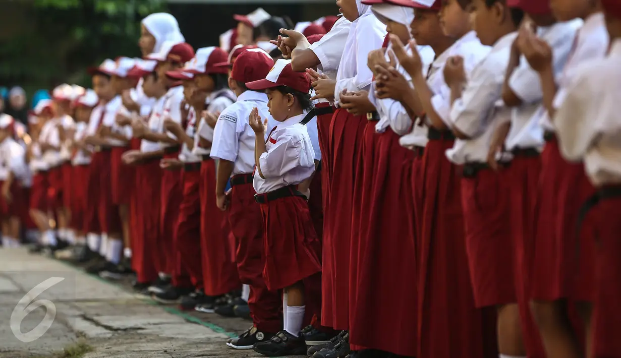 Seorang siswi tampak berdoa saat upacara pada hari pertama sekolah di SDN Pasar Baru 05 Jakarta, Senin (18/7). Usai libur Idul Fitri, para siswa kembali beraktivitas mengikuti pelajaran di sekolah untuk tahun ajaran 2015-2016. (Liputan6.com/Faizal Fanani)