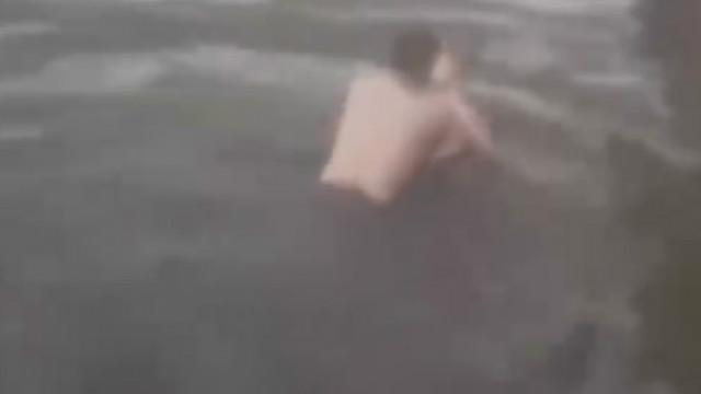 Suami mencoba menarik istri dari dalam air | Photo: Copyright shanghaiist.com
