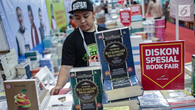 Seorang pria merapihkan buku selama Islamic Book Fair 2019 di Jakarta Convetion Center, Jakarta, Rabu (27/2). Pameran buku ini berlangsung hingga 3 Maret. (Liputan6.com/Faizal Fanani)