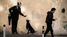 Seorang pria berjalan melewati mural yang diduga karya seniman sekaligus aktivis Banksy di Paris, Prancis, Minggu (24/6). Tujuh mural terbaru telah ditemukan di Paris dalam beberapa hari terakhir. (PHILIPPE LOPEZ/AFP)