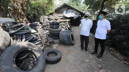 Anggota Komisi XI DPR RI Kamrussamad bersama warga saat melihat ban bekas yang akan diproduksi untuk UMKM di Juanda Depok, Jawa Barat, Selasa (20/7/2021). Pada penerapan kebijakan PPKM Darurat, Kamrussamad berharap terus mendorong usaha kecil di masa pandemi. (Liputan6.com/HO/Bon)