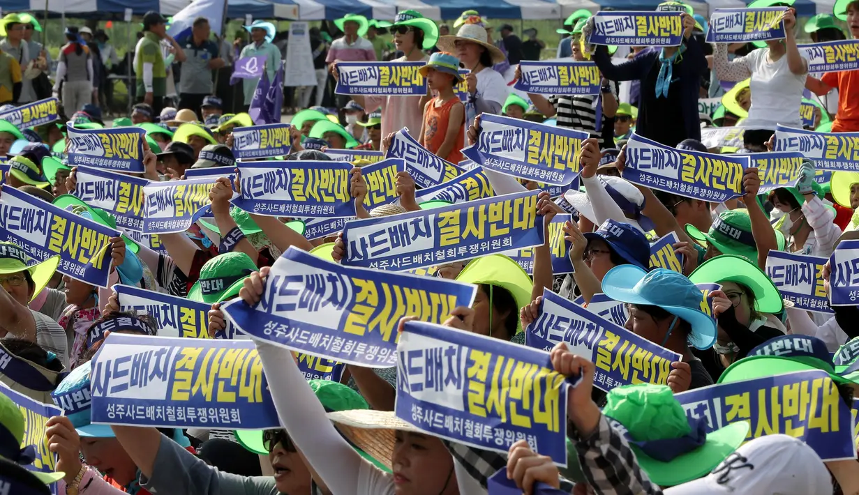Warga membawa selembaran sambil melontarkan protes terhadap keputusan pemerintah yang menempatkan alat pertahanan anti rudal AS Terminal High Altitude Area Defence (THAAD) di Seongju, Korea Selatan, Senin (15/8).( Reuters/Kim Jun- beom)