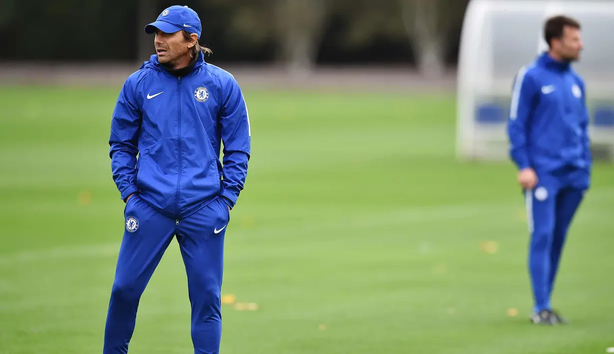 Pelatih Chelsea, Antonio Conte melihat para pemainnya berlatih di London, Inggris (17/10). Chelsea akan bertanding melawan wakil Italia, AS Roma pada grup C Liga Champions. (AFP Photo/Glyn Kirk)