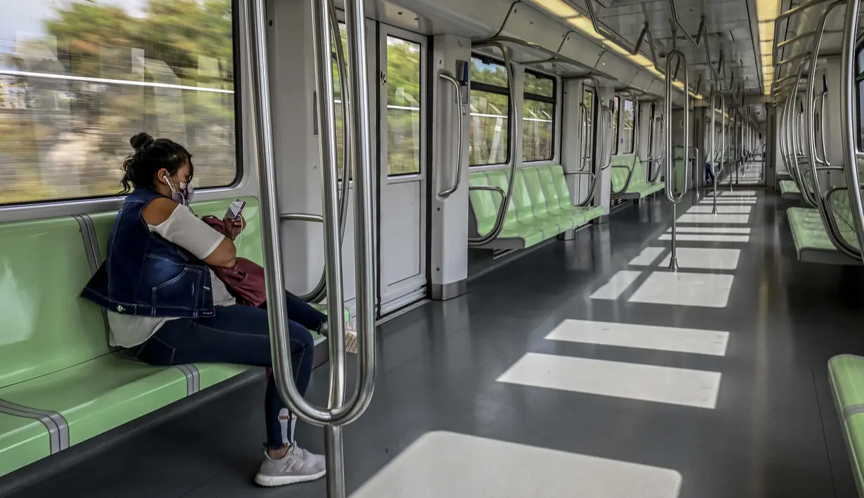Seorang perempuan duduk di sebuah kereta yang kosong saat orang-orang tinggal di rumah untuk memurus rantai penularan pandemi COVID-19 di Medellin, pada 21 Maret 2020. Presiden Kolombia Ivan Duque mengumumkan isolasi mulai 24 Maret hingga 13 April 2020. (Photo by JOAQUIN SARMIENTO / AFP)
