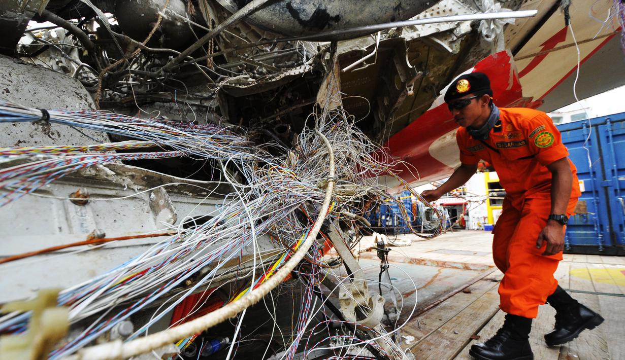 Petugas dari Basarnas memeriksa bangkai badan pesawat Airasia QZ8501 di Pelabuhan Tanjung Priok, Jakarta, Senin (2/3/2015). (Liputan6.com/Faizal Fanani)