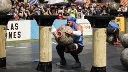 Johan Els dari Afrika Selatan mengangkat batu pada kompetisi pria terkuat di dunia atau World’s Strongest Man di Manila, Filipina, 5 Mei 2018. Para peserta harus mengikuti 6 tantangan untuk menyandang gelar manusia terkuat di planet bumi. (NOEL CELIS/AFP)